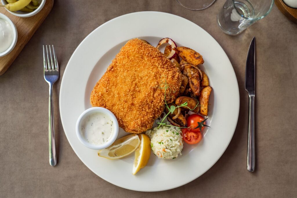 Wiener schnitzel with roast potatoes and tartar sauce, shot from above