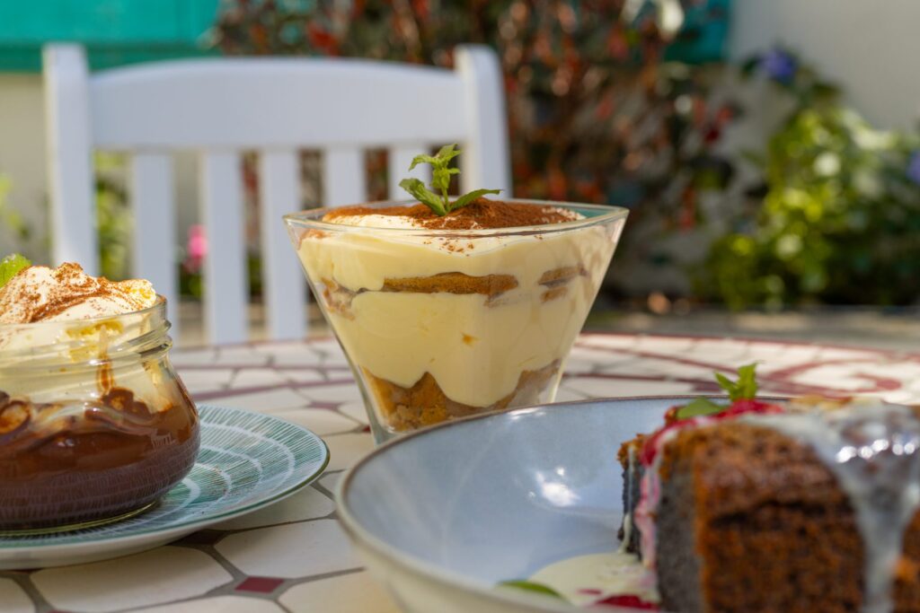 Tiramisu and cakes on a table in a restaurant garden