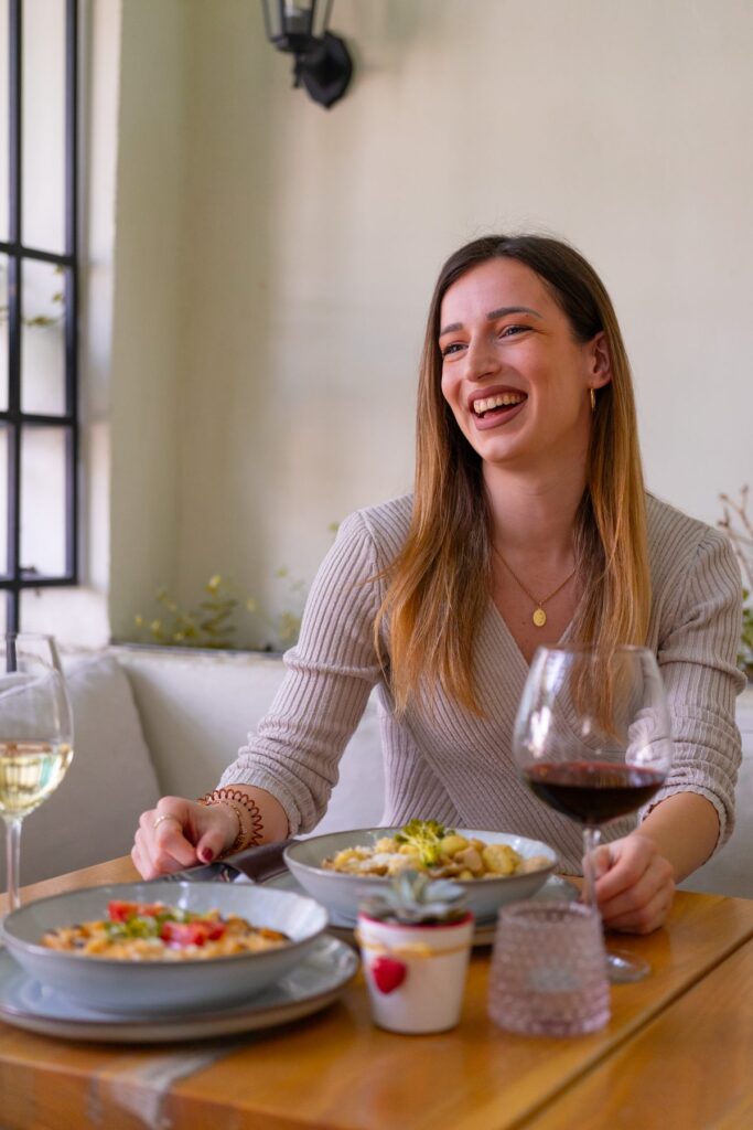 Guest at a table with a glass of wine and a starter