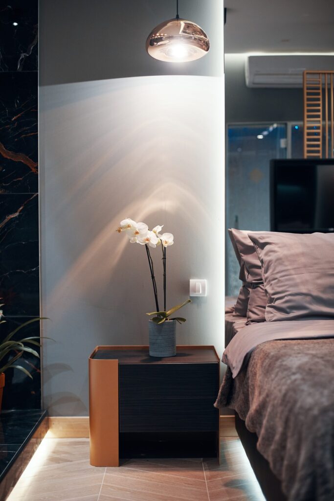 Orchid and lamp on a bedside table in an apartment