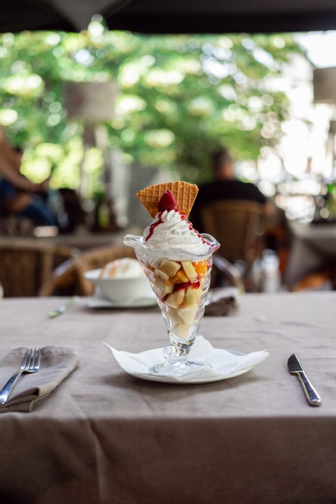 Ice cream sundae with a wafer, served in a garden