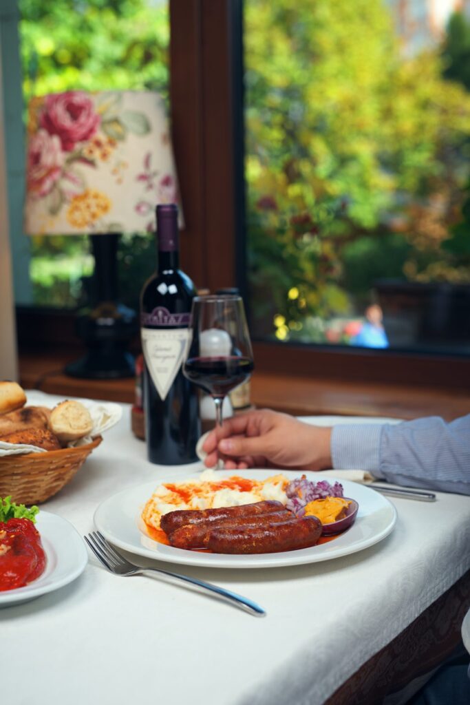 Set table in a garden with a bottle of wine and a main course